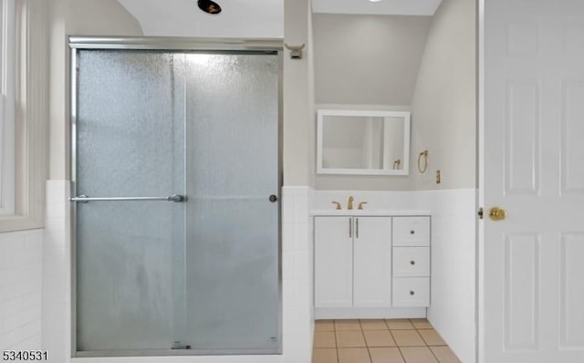 full bath featuring a wainscoted wall, a shower stall, vanity, and tile patterned floors