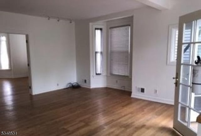 spare room featuring wood finished floors and baseboards