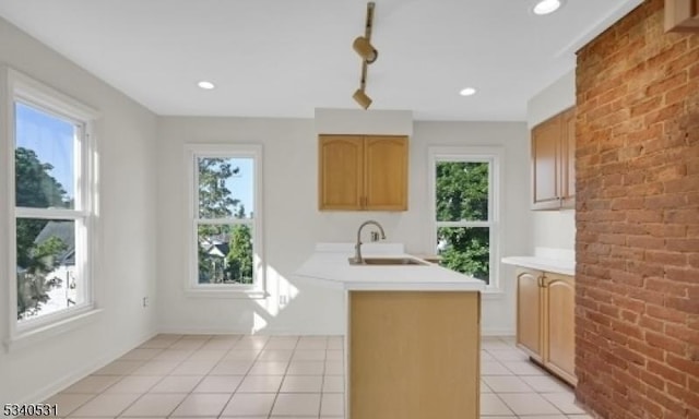 kitchen with light tile patterned floors, light countertops, a sink, and a healthy amount of sunlight