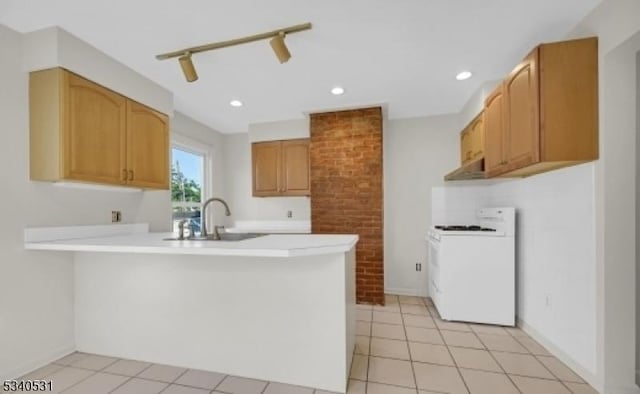 kitchen featuring light countertops, electric range, a sink, a peninsula, and under cabinet range hood