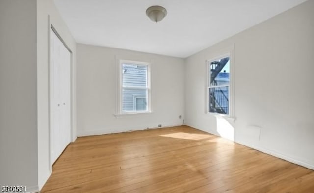 unfurnished bedroom featuring a closet and light wood-type flooring