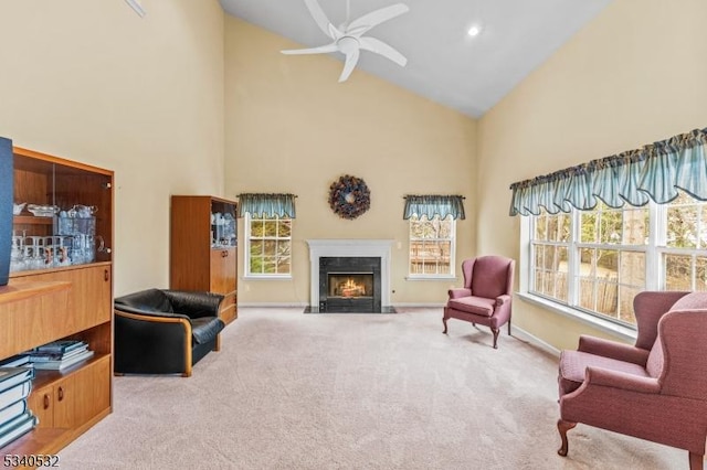 sitting room featuring baseboards, ceiling fan, a premium fireplace, carpet, and high vaulted ceiling