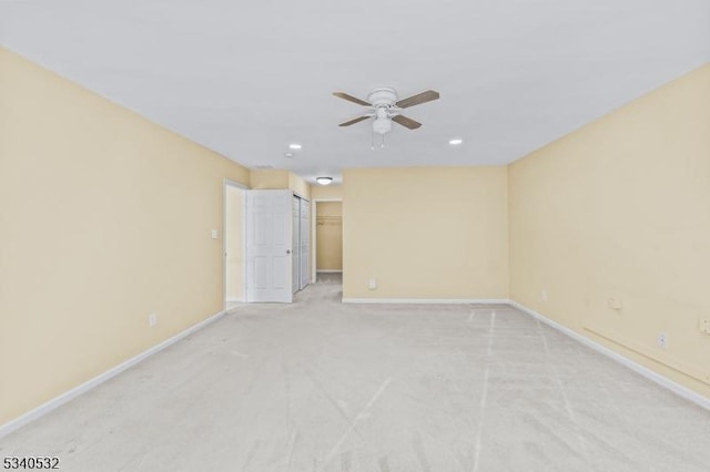 empty room with ceiling fan, recessed lighting, light colored carpet, and baseboards