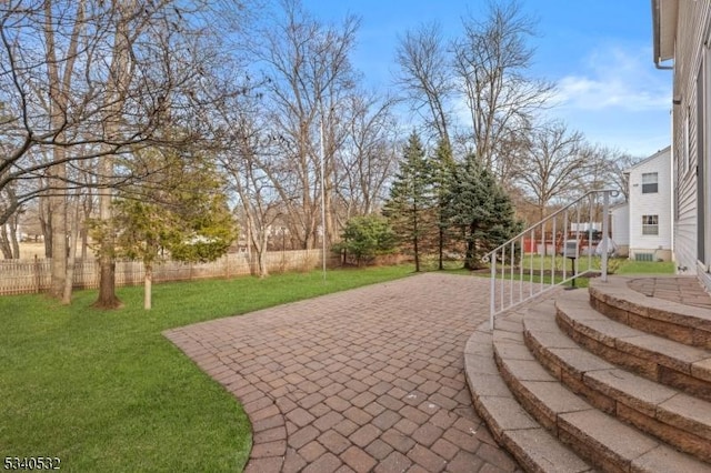 view of community featuring a lawn, a patio area, and fence