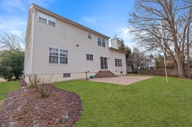 rear view of property featuring entry steps, a patio, a lawn, and fence