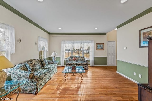 living area featuring baseboards, recessed lighting, wood finished floors, and crown molding