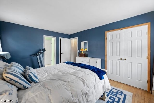 bedroom with light wood-type flooring and a closet