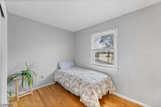 bedroom featuring baseboards and wood finished floors