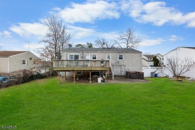 back of property featuring a deck, a lawn, and fence