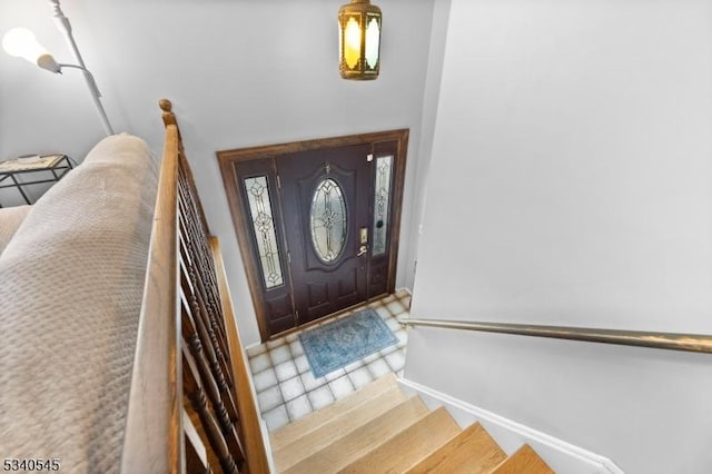 foyer entrance featuring baseboards and stairway