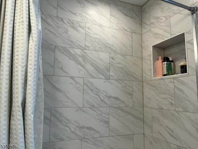 interior details with a tile shower