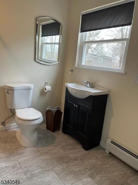 bathroom featuring baseboards, toilet, vanity, and baseboard heating