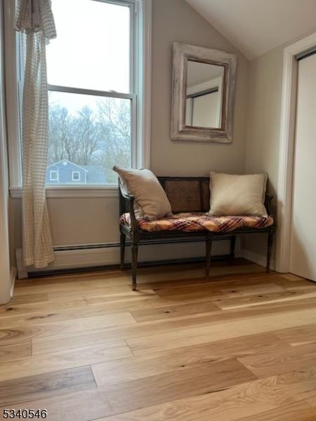 sitting room with lofted ceiling and light wood finished floors