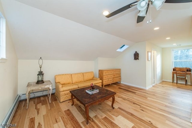 living room with lofted ceiling, a baseboard heating unit, light wood-type flooring, and baseboards