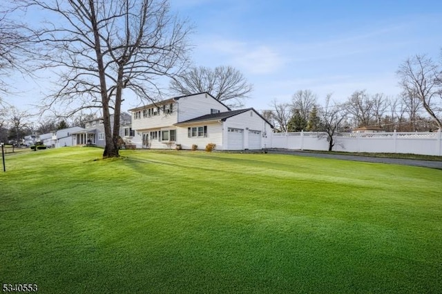 view of yard with fence and an attached garage