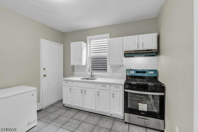 kitchen featuring refrigerator, light countertops, gas stove, a sink, and under cabinet range hood