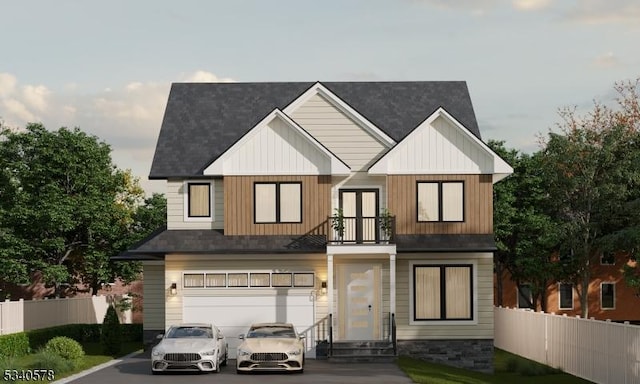 view of front of property featuring a balcony, driveway, a garage, and fence