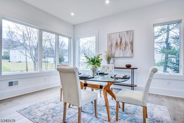 dining room featuring visible vents, a wealth of natural light, and wood finished floors