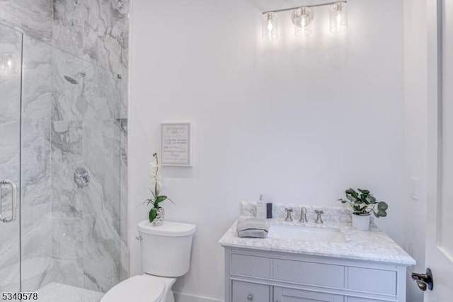 bathroom with toilet, vanity, and a marble finish shower