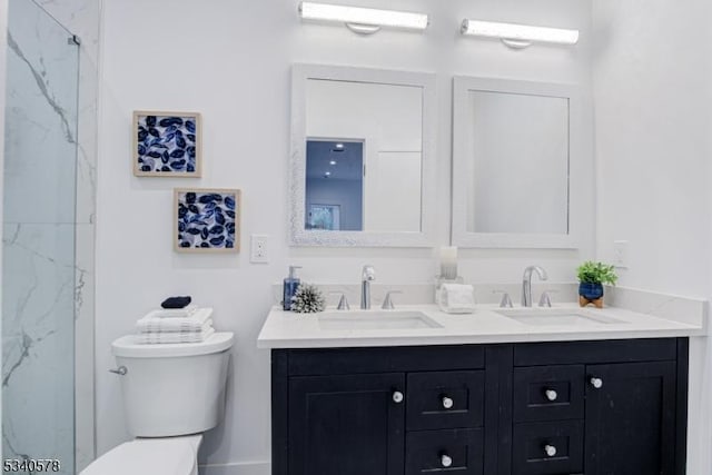 bathroom with a marble finish shower, a sink, toilet, and double vanity