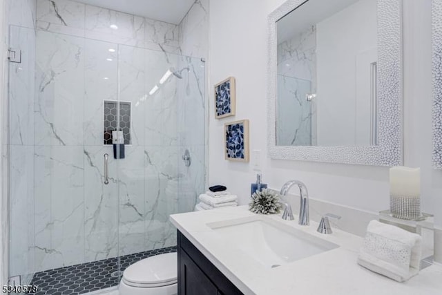 full bathroom featuring toilet, a marble finish shower, and vanity