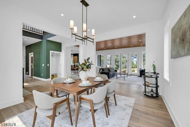 dining area with light wood-type flooring, baseboards, a notable chandelier, and recessed lighting