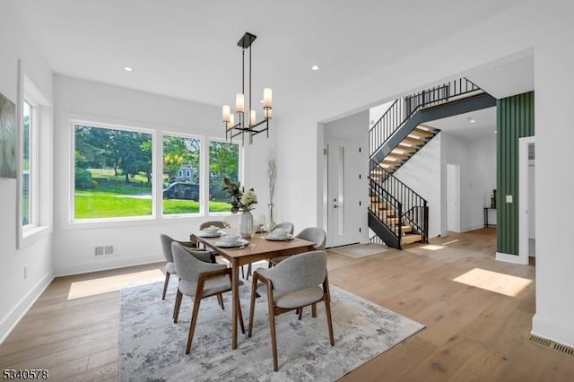 dining room with a chandelier, recessed lighting, stairway, and wood finished floors