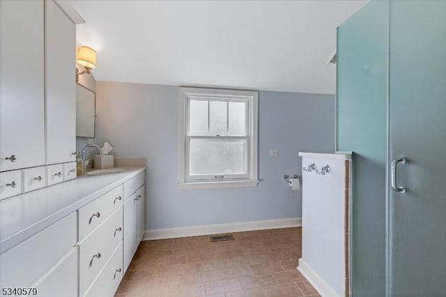 full bath with visible vents, a shower with shower door, vanity, and baseboards