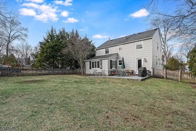 rear view of property featuring a fenced backyard, a lawn, and a patio