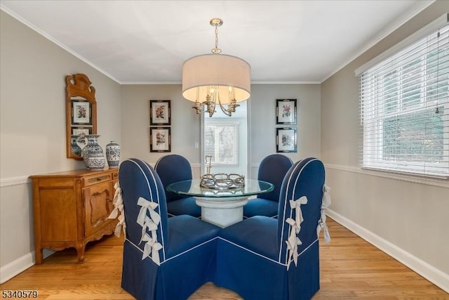 dining area with ornamental molding, light wood-type flooring, an inviting chandelier, and baseboards