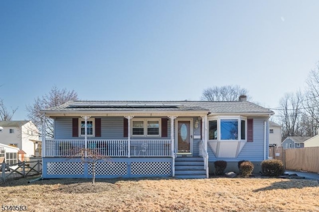 view of front of home featuring covered porch and a front lawn