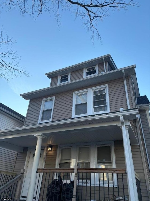 american foursquare style home featuring covered porch