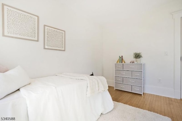 bedroom with baseboards and wood finished floors