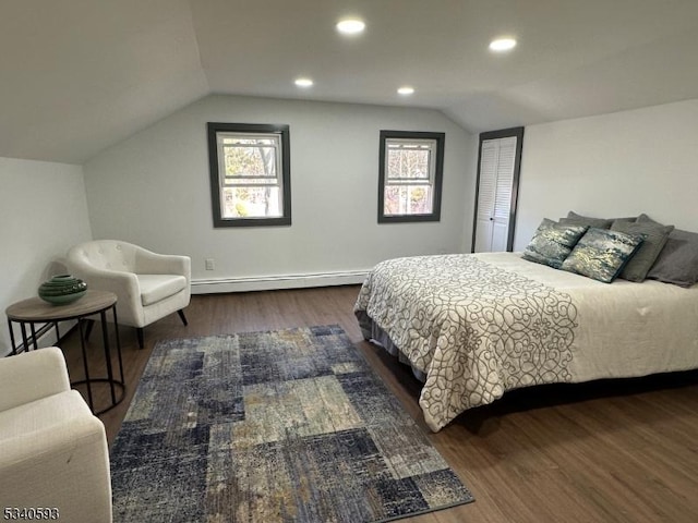 bedroom featuring a baseboard heating unit, vaulted ceiling, multiple windows, and wood finished floors