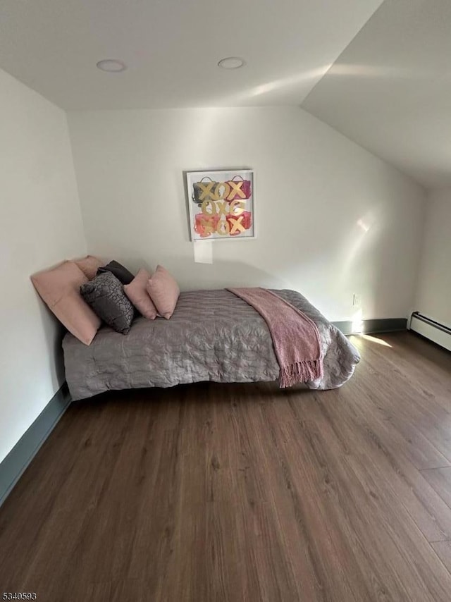 bedroom with vaulted ceiling, baseboards, and wood finished floors