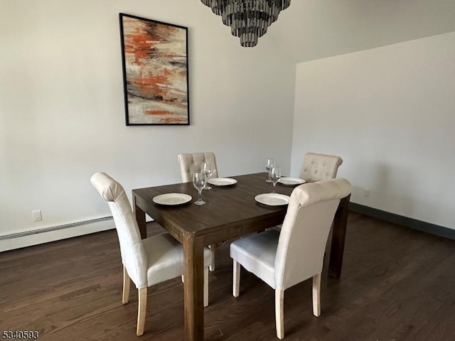 dining room featuring a baseboard heating unit, baseboards, wood finished floors, and a chandelier