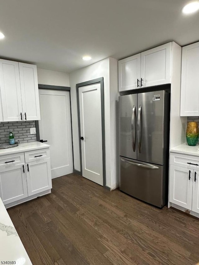 kitchen with dark wood-style floors, recessed lighting, freestanding refrigerator, white cabinets, and backsplash