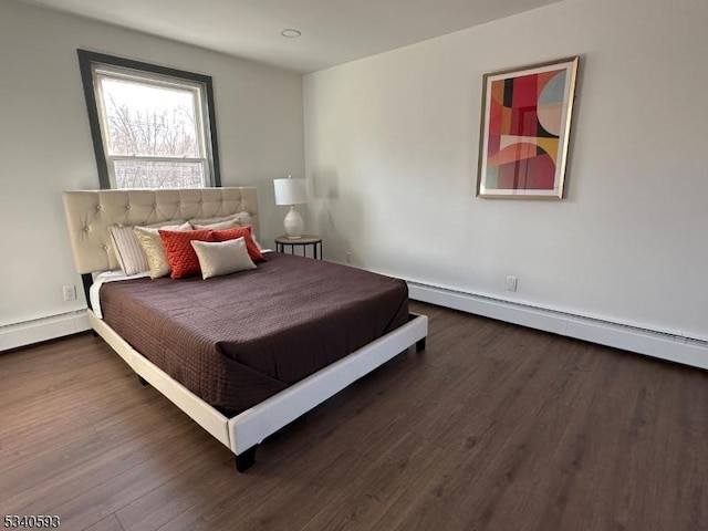 bedroom with wood finished floors and baseboard heating