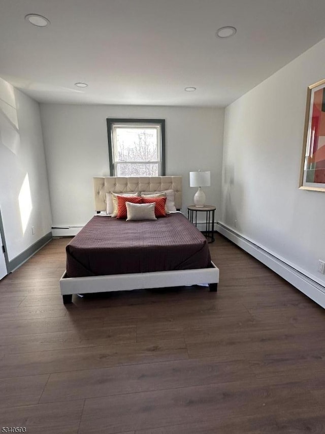 bedroom with recessed lighting, wood finished floors, baseboards, and a baseboard radiator