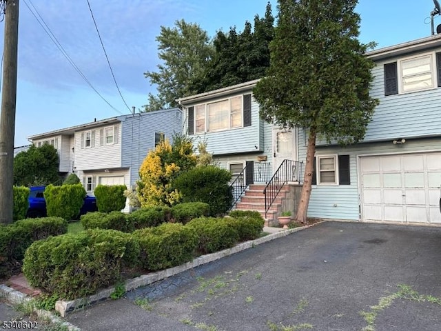 split foyer home with an attached garage and aphalt driveway