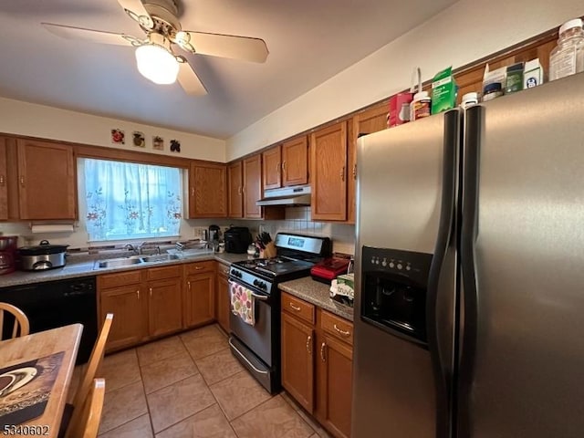 kitchen featuring under cabinet range hood, a sink, range with gas stovetop, stainless steel fridge with ice dispenser, and brown cabinets