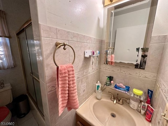 bathroom featuring a stall shower, tile walls, toilet, and vanity