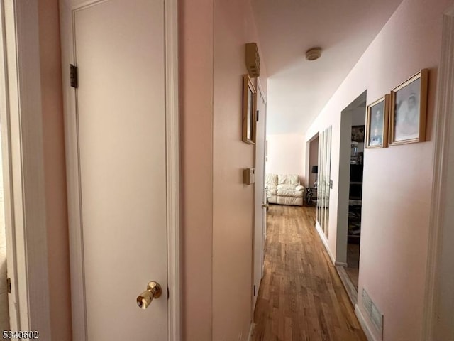 corridor with wood finished floors and visible vents