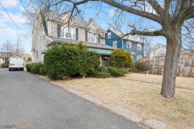 view of front of property featuring an outdoor structure and a chimney