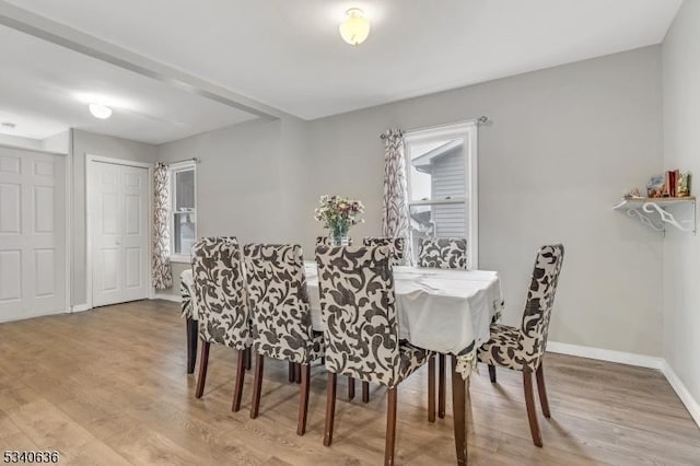 dining room featuring light wood-style floors, baseboards, and a wealth of natural light