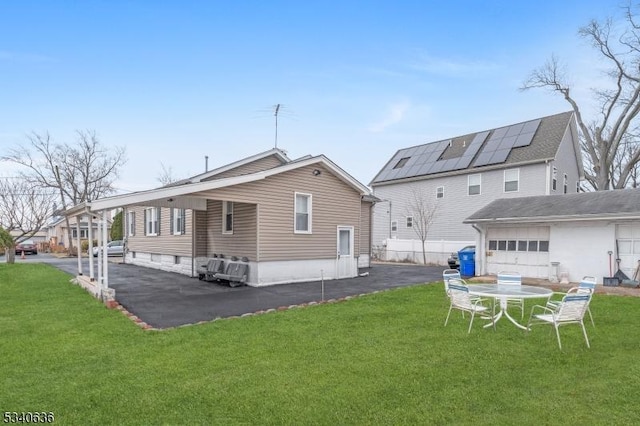 rear view of house featuring a yard, fence, and driveway