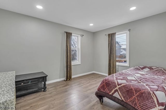 bedroom featuring baseboards, wood finished floors, and recessed lighting