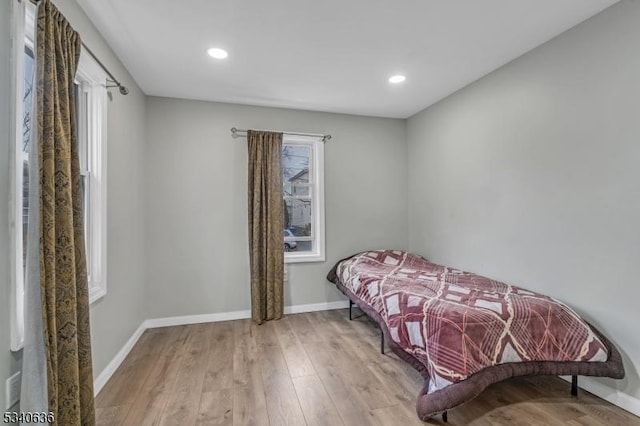 bedroom with baseboards, wood finished floors, and recessed lighting