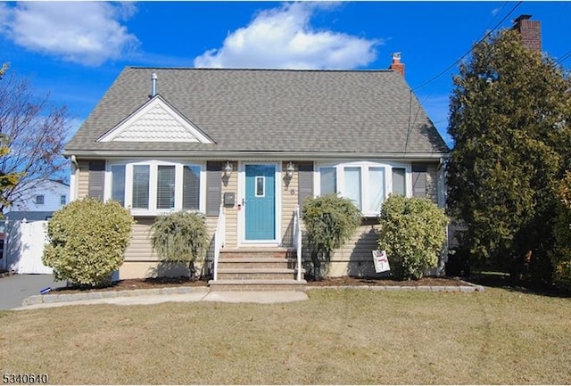 view of front of property with roof with shingles and a front yard