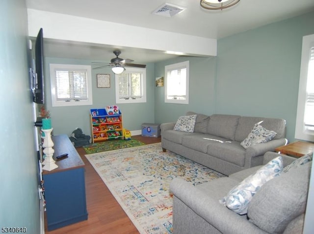 living area with visible vents, ceiling fan, and wood finished floors